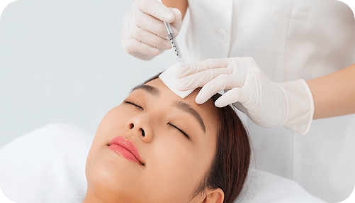 Doctor performing facial injection treatment on a patient’s forehead